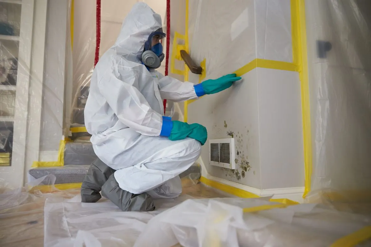 NORMI-certified technician performing mold remediation in protective containment area